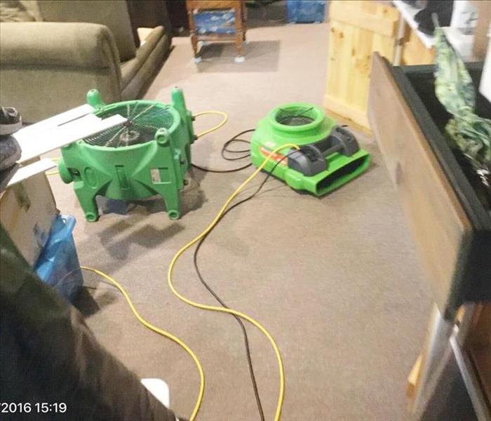 Air movers set on carpet with couch and furniture and contents around on the floor