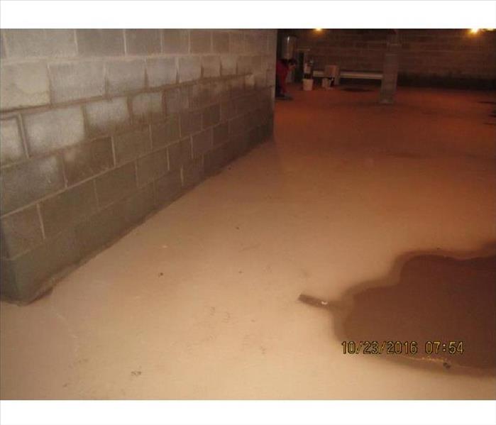 Layer of dry and wet mud on concrete basement floor