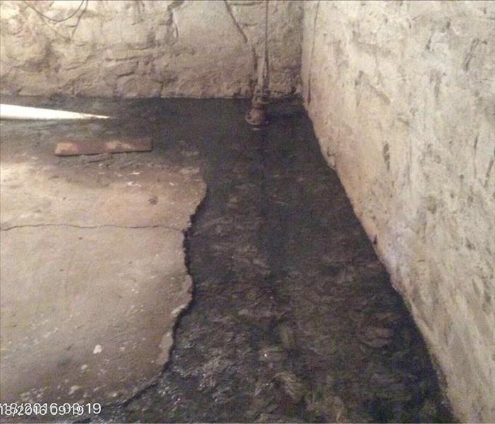 Concrete and stone basement with sewage water around the edges